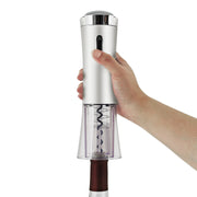 Sleek silver electric wine opener with a transparent base and integrated corkscrew held by a hand over a wine bottle.