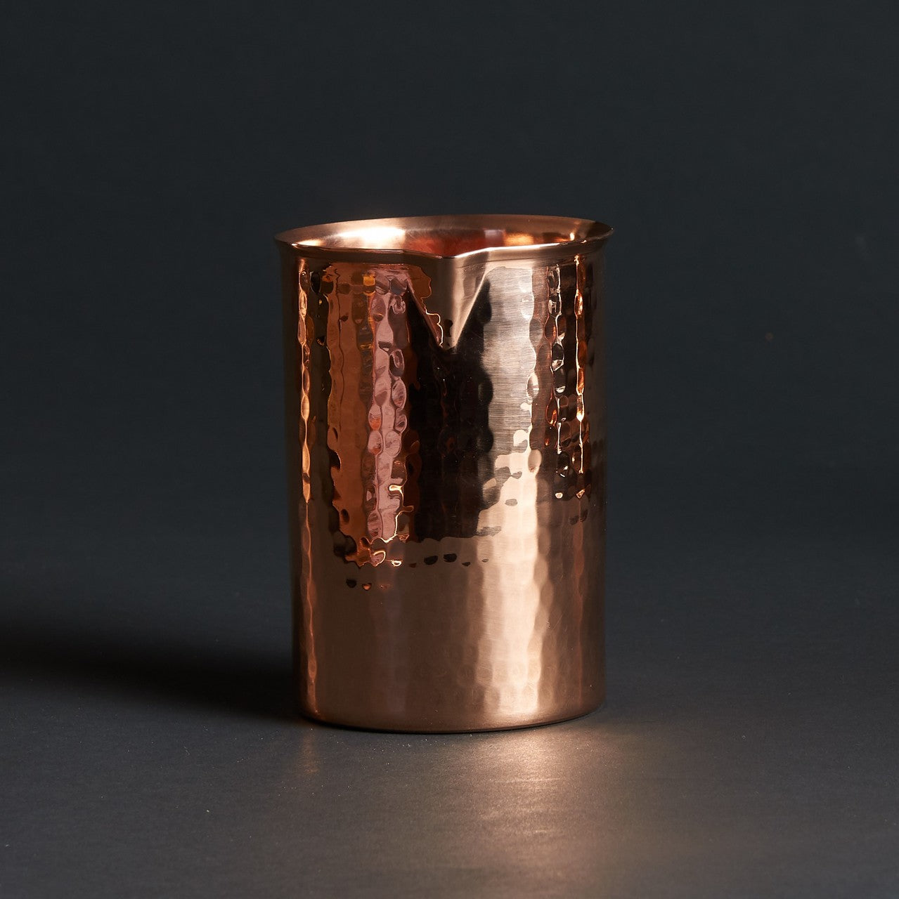 Hammered copper cocktail glass with a flat bottom and pouring spout, 20-ounce capacity.