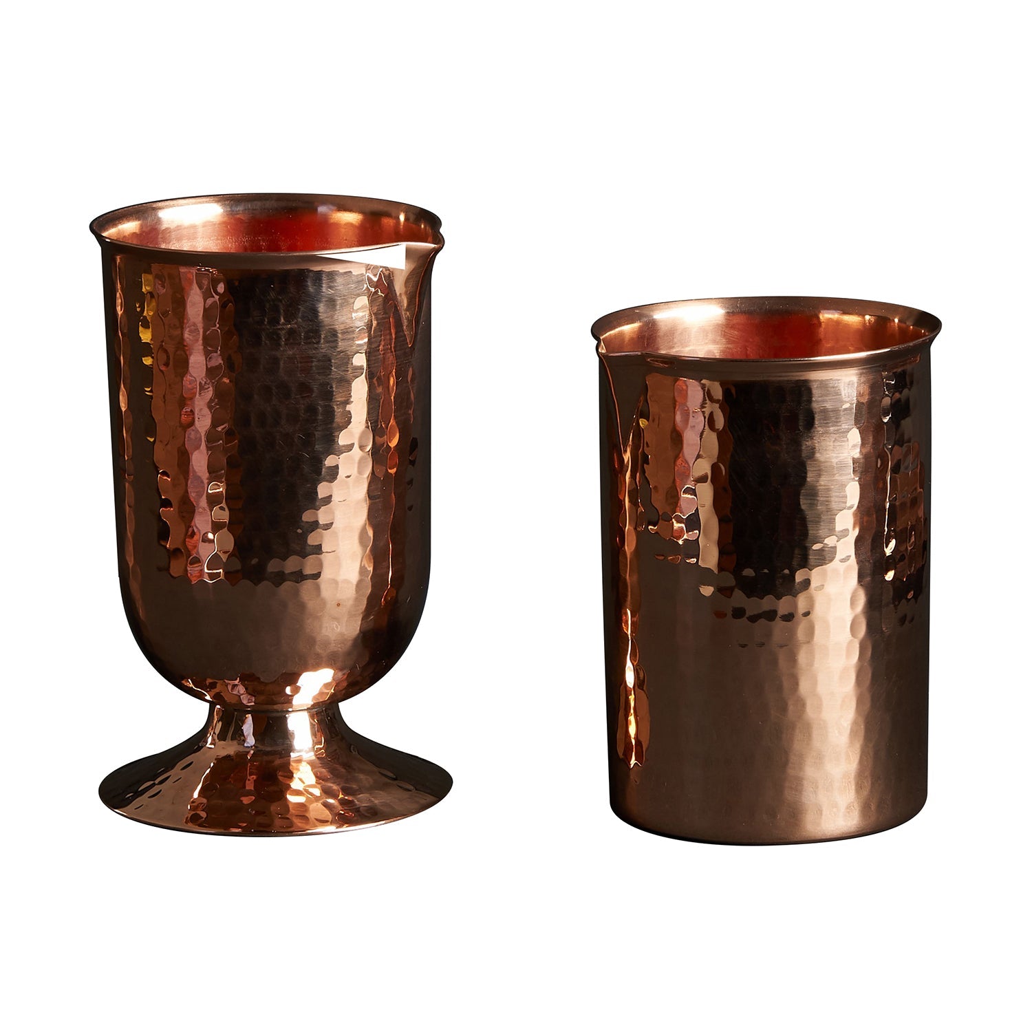 Two hammered copper cocktail glasses: one rounded with a pedestal base, one flat-bottomed.