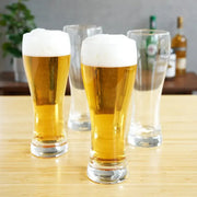 Set of 4 clear 23 oz True Wheat Beer Glasses, two filled with golden beer and foam, on a wooden table.