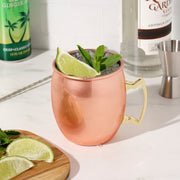 16 oz polished copper Moscow Mule mug with a sturdy brass-colored handle, garnished with lime and mint.