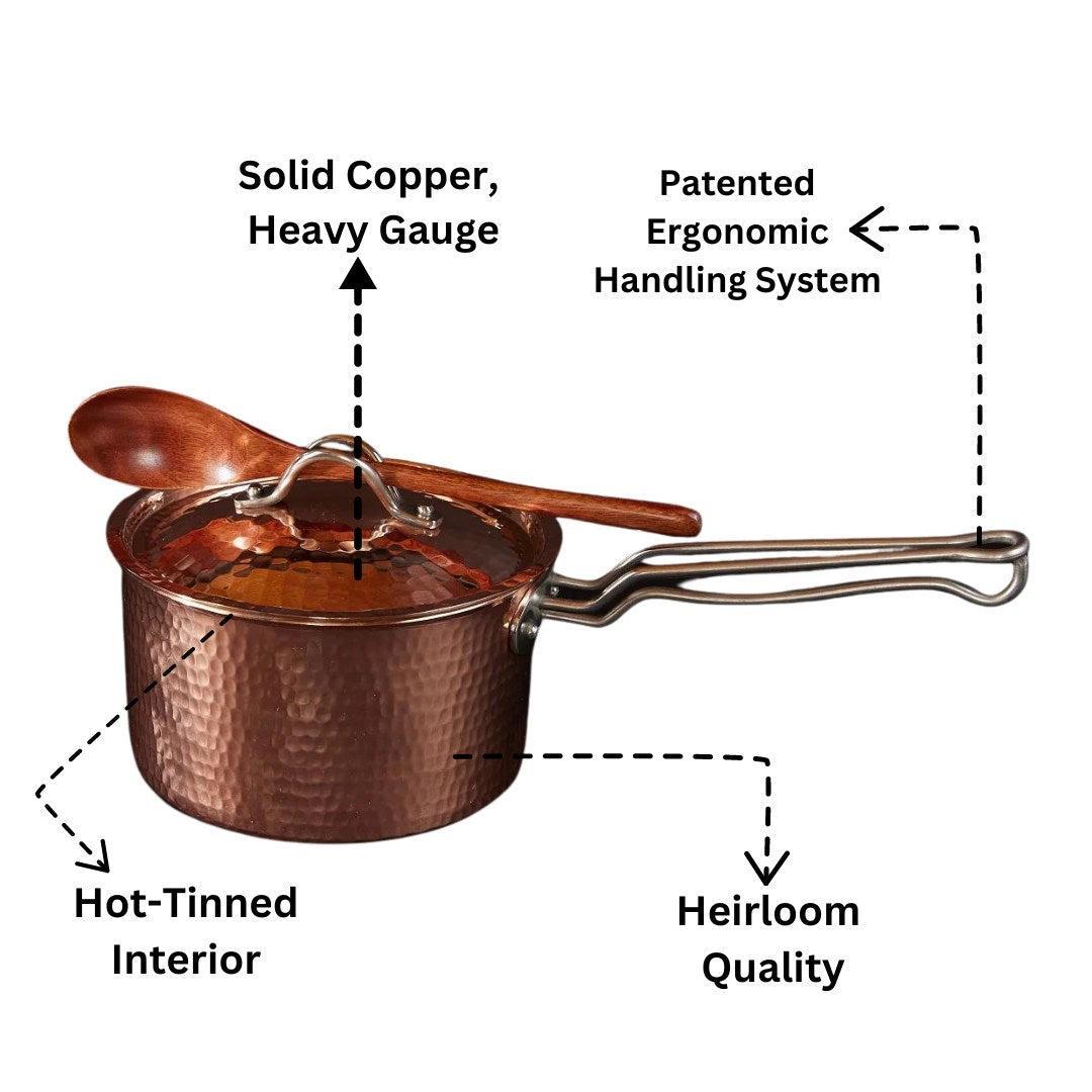 Hammered copper saucepan with lid and wooden spoon, featuring a patented ergonomic handle.