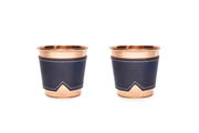 Two 12 oz hammered copper mugs with indigo leather sleeves and white stitching.