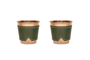 Two 12 oz hammered copper mugs with olive leather sleeves and white stitching.