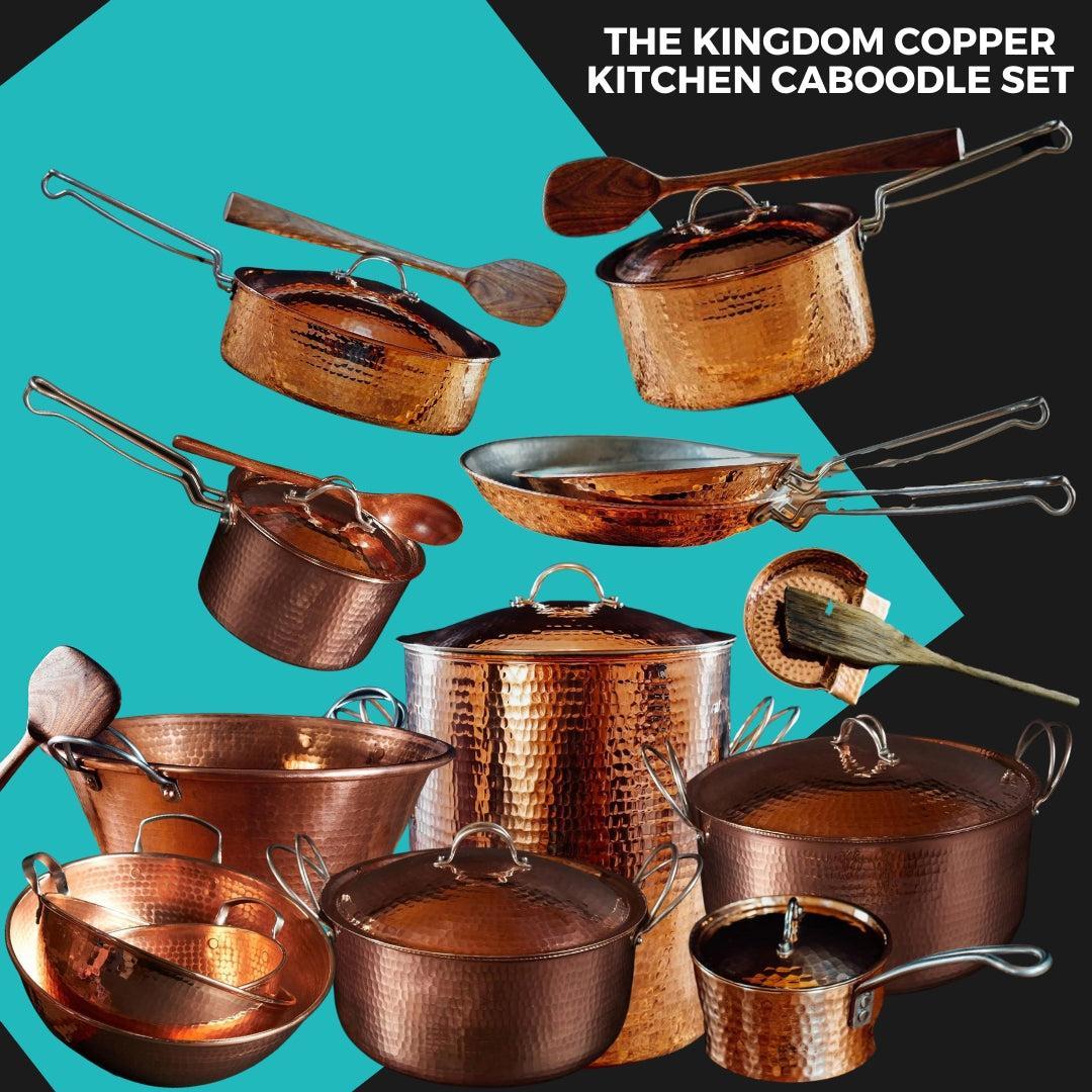 A collection of hammered copper pots, pans, and mixing bowls with wooden utensils.