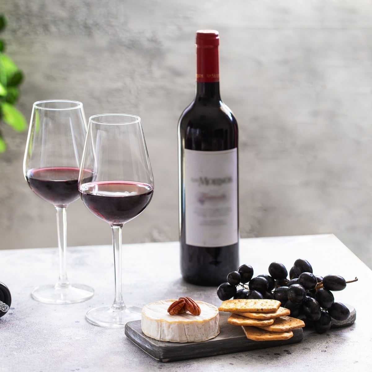 Bordeaux wine glass beside Pacific marble cheese board for tasting