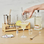 Stainless steel True Mixologist Barware Set on a bamboo stand, pouring a margarita.